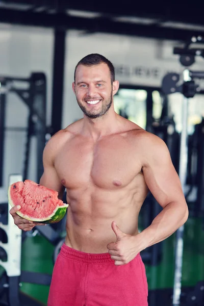 Schöner Bodybuilder mit Wassermelone — Stockfoto