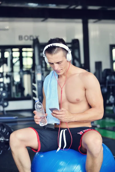 Mann in Sportbekleidung hört Musik im Fitnessstudio — Stockfoto