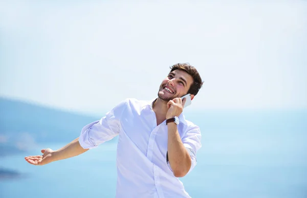 Hombre joven usando teléfono móvil — Foto de Stock