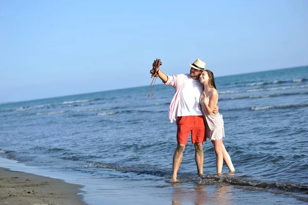 Pareja feliz en la orilla del mar — Foto de Stock