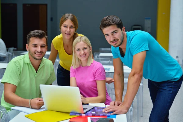 Four students sitting in cafe after classes in university