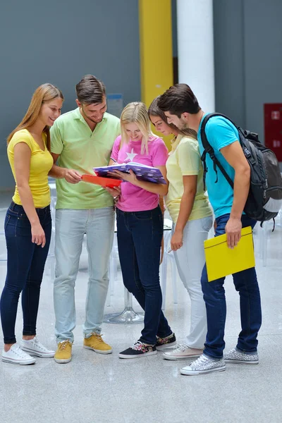 Group of students standing with books in university building