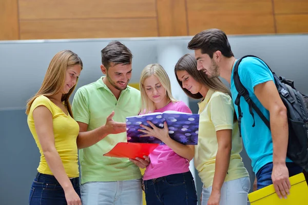Group of students standing with books in university building