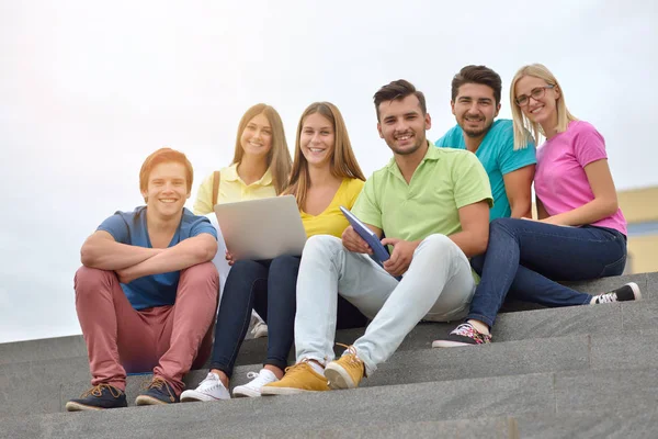 Grupa Studentów Siedząc Schodach Nowoczesnych Gadżetów Tle Budynku Uniwersytetu — Zdjęcie stockowe