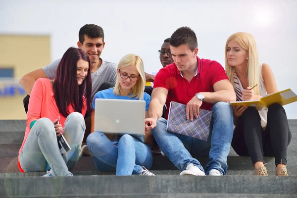 Fotografía de un grupo de estudiantes universitarios sonrientes mirando algo —  Fotos de Stock