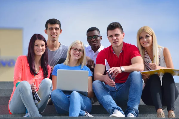 Fotografía de un grupo de estudiantes universitarios sonrientes mirando algo —  Fotos de Stock