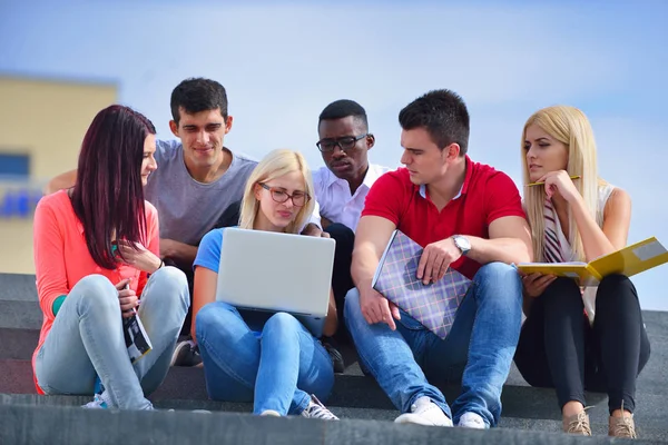 Fotografía de un grupo de estudiantes universitarios sonrientes mirando algo —  Fotos de Stock