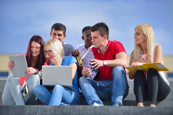 Fotografía de un grupo de estudiantes universitarios sonrientes mirando algo —  Fotos de Stock