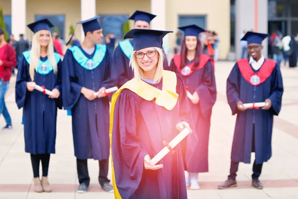 Hermosa chica de graduación sosteniendo su diploma con orgullo —  Fotos de Stock