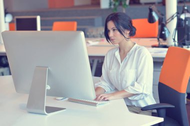 Ofiste bilgisayar başında çalışan bir kadın.