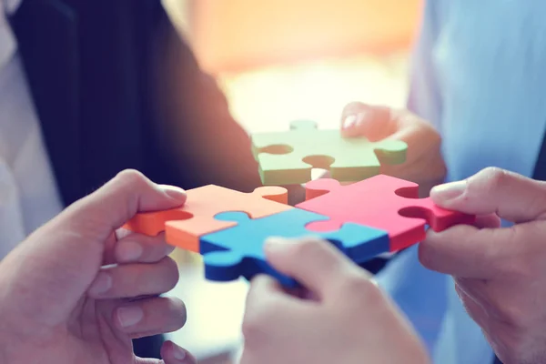 Group of business people assembling jigsaw puzzle and represent — Stock Photo, Image