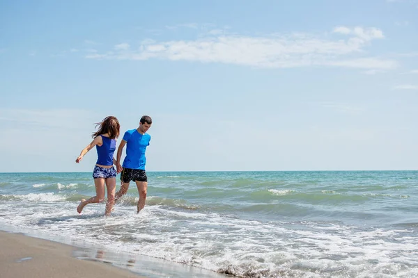 Pareja Joven Divirtiéndose Juntos Mientras Corren Saltan Agua Playa —  Fotos de Stock