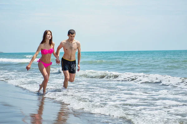 Pareja Joven Divirtiéndose Juntos Mientras Corren Saltan Agua Playa —  Fotos de Stock