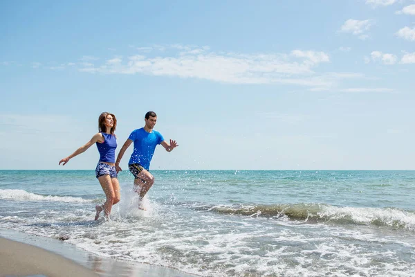 Jovem Casal Divertindo Juntos Enquanto Correndo Pulando Água Praia — Fotografia de Stock