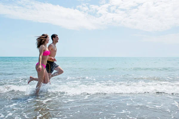 Giovane Coppia Divertirsi Insieme Durante Corsa Saltare Acqua Spiaggia — Foto Stock