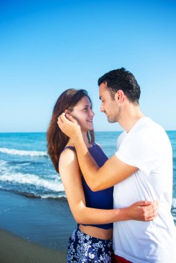  Deniz arka planında birlikte poz veren çift 