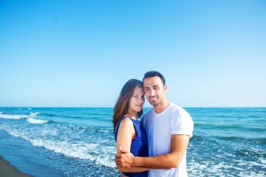  Deniz arka planında birlikte poz veren çift 