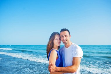  Deniz arka planında birlikte poz veren çift 