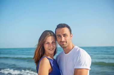  Deniz arka planında birlikte poz veren çift 