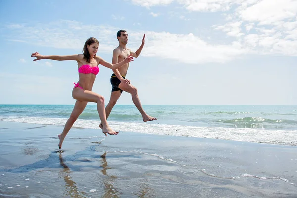 Pareja Joven Divirtiéndose Juntos Mientras Corren Saltan Agua Playa —  Fotos de Stock