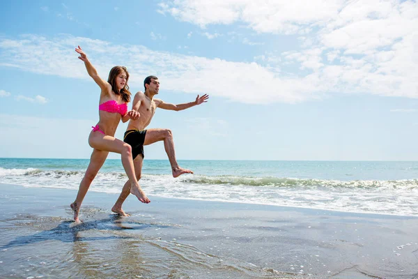 Pareja Joven Divirtiéndose Juntos Mientras Corren Saltan Agua Playa — Foto de Stock