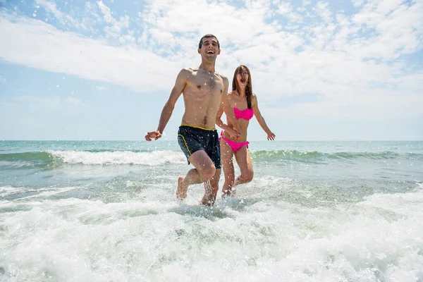 Pareja Joven Divirtiéndose Juntos Mientras Corren Saltan Agua Playa — Foto de Stock