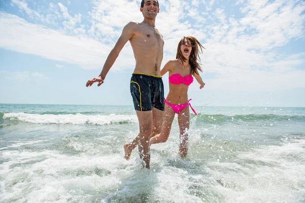 Giovane Coppia Divertirsi Insieme Durante Corsa Saltare Acqua Spiaggia — Foto Stock