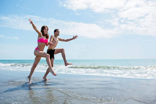 Pareja Joven Divirtiéndose Juntos Mientras Corren Saltan Agua Playa —  Fotos de Stock