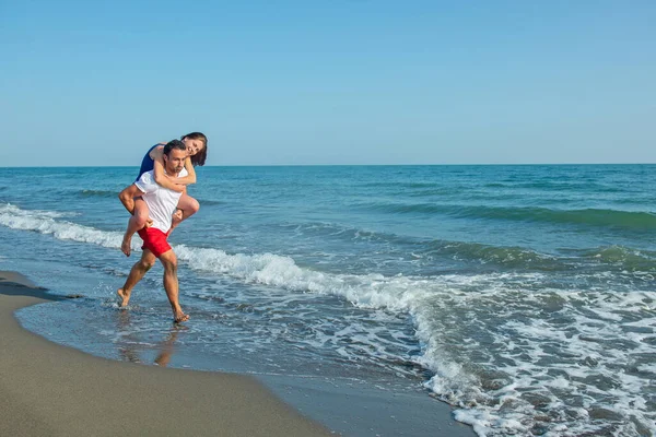 Άντρας Που Κουβαλάει Γυναίκα Στην Πλάτη Του Στην Παραλία — Φωτογραφία Αρχείου