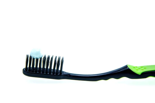 Черная зубная щетка и зубная паста на белом фоне — стоковое фото