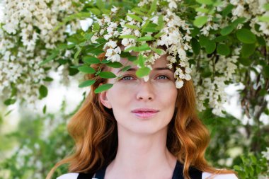 Kızıl saçlı modeli arasında çiçek akasya