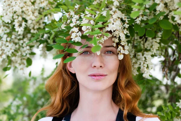 Kızıl saçlı modeli arasında çiçek akasya