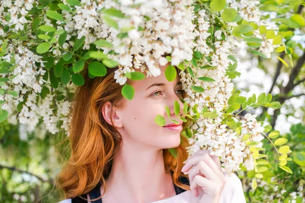 Kızıl saçlı modeli arasında çiçek akasya