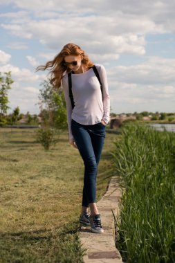 Kızıl saçlı modeli parapetin üzerinde teetering