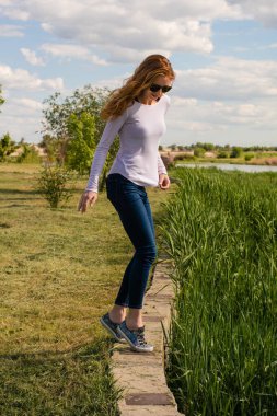 Kızıl saçlı modeli parapetin üzerinde teetering