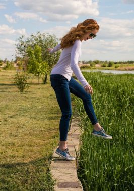 Kızıl saçlı modeli parapetin üzerinde teetering