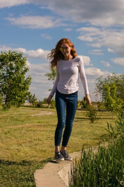 Kızıl saçlı modeli parapetin üzerinde teetering