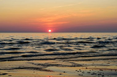 Denizde güzel bir gün batımı. Günbatımında Baltık Denizi, Narva-Joesuu, Estonya. Narva-Joesuu - Estonya 'da deniz kenarı tatil beldesi ve popüler tatil beldesi