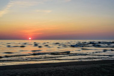 Denizde güzel bir gün batımı. Günbatımında Baltık Denizi, Narva-Joesuu, Estonya. Narva-Joesuu - Estonya 'da deniz kenarı tatil beldesi ve popüler tatil beldesi