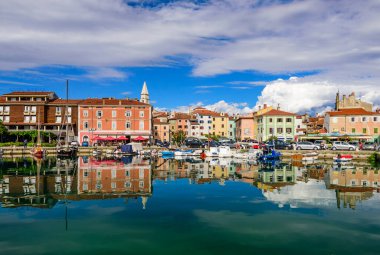 Izola, Slovenya - 20 Eylül 2016: Izola 'da deniz kıyısında tekneleri ve parlak renkli evleri olan manzaralı liman. Slovenya 'yı gezmek, popüler turizm beldesi