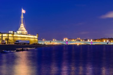 St. Petersburg gece manzarası: Peter ve Paul kalesi, Neva nehri ve Trinity köprüsü akşam aydınlığında