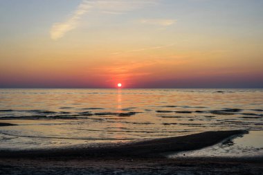 Denizde güzel bir gün batımı. Günbatımında Baltık Denizi, Narva-Joesuu, Estonya. Narva-Joesuu - Estonya 'da deniz kenarı tatil beldesi ve popüler tatil beldesi
