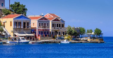 Suriye Adası, Dodecanese Adaları, Yunanistan - 18 Mayıs 2016: Yunanistan 'ı gezmek. Symi adasının şehir manzarası. Symi adasının kıyı şeridindeki binaların geleneksel parlak cepheleri