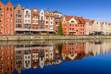 Gdansk, Polonya - 7 Ekim 2019: Polonya turu. Gdansk 'ın şehir manzarası. Deniz kıyısındaki Moltava nehrindeki güzel binaların cephelerinde su yansıması var.