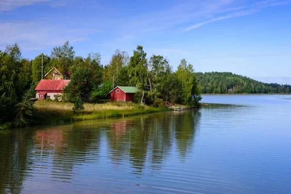 Picturesque lake with wooden houses on the shore, typical nature of Finland.