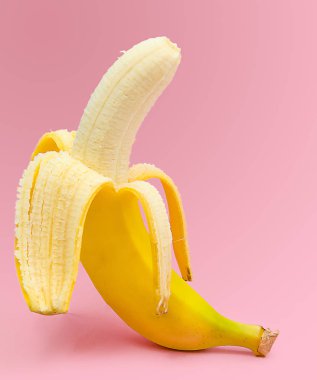 Pembe bir arka plan üzerinde taze soyulmuş muz