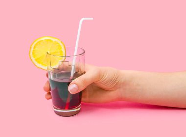 Taze meyve suyu cam bir saman dilim pembe bir arka plan üzerinde sarı limon ile. Moda pastel yaz tasarım stil