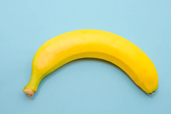 One yellow banana on a blue background