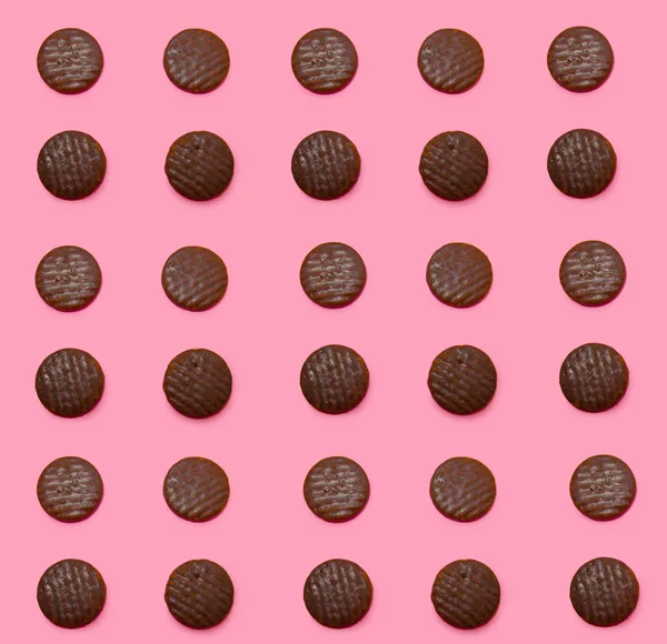 ピンクの背景に自家製チョコレート クッキーの行 — ストック写真