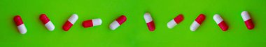 Yeşil bir arka plan üzerinde kapsül kırmızı hap şekli